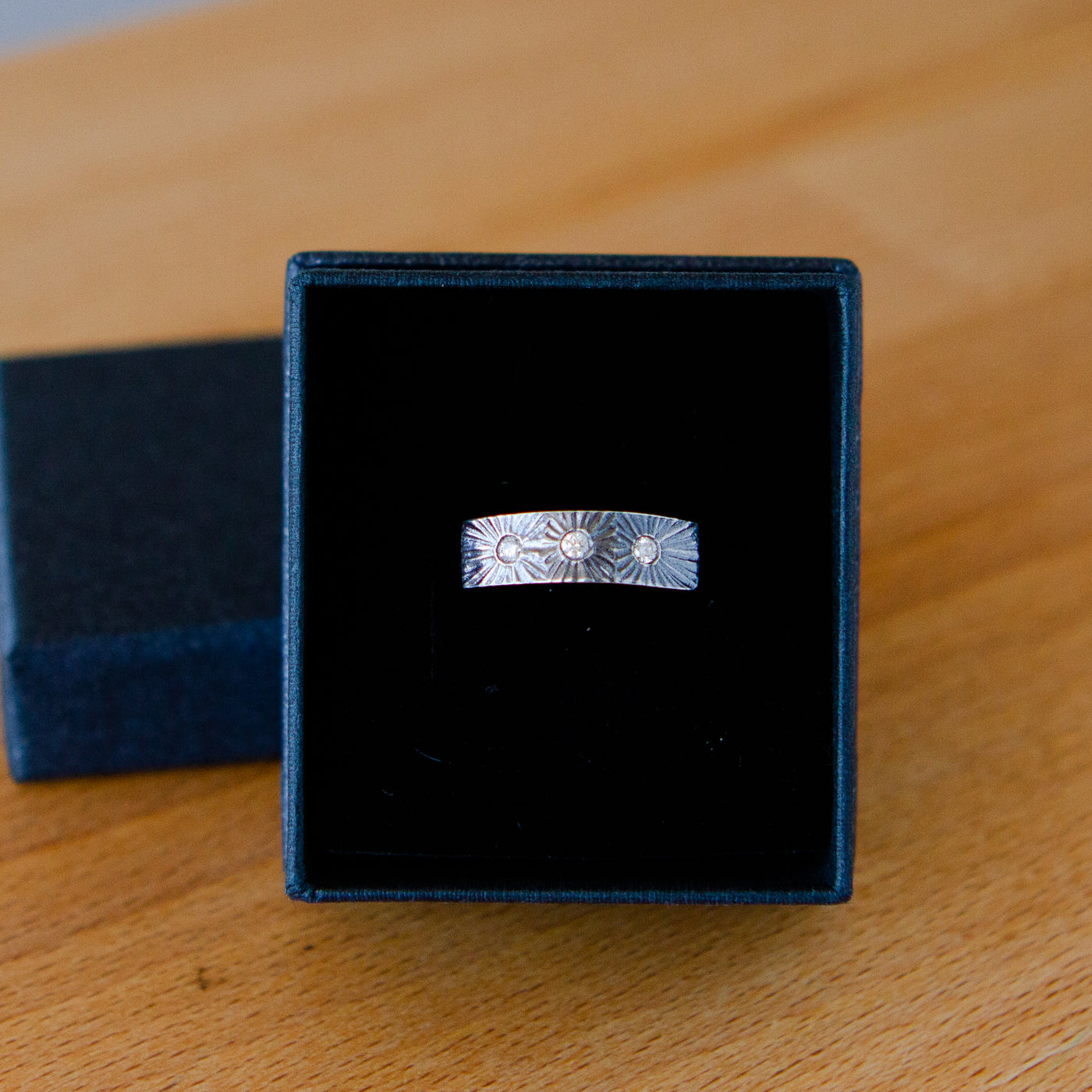 Nova Oxidized Silver and Diamond Ring by Corey Egan in a ring box
