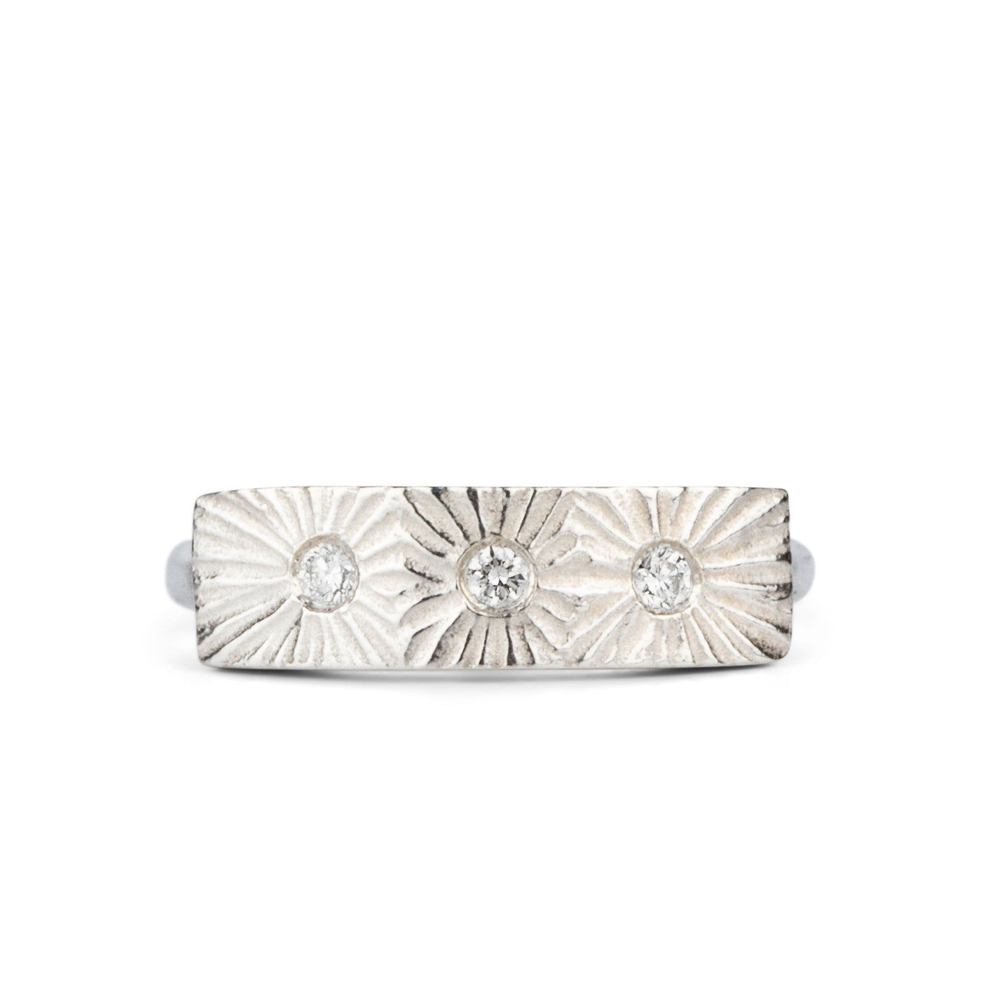 Sterling silver bar ring with three diamonds and a carved sunburst design around each by Corey Egan on a white background