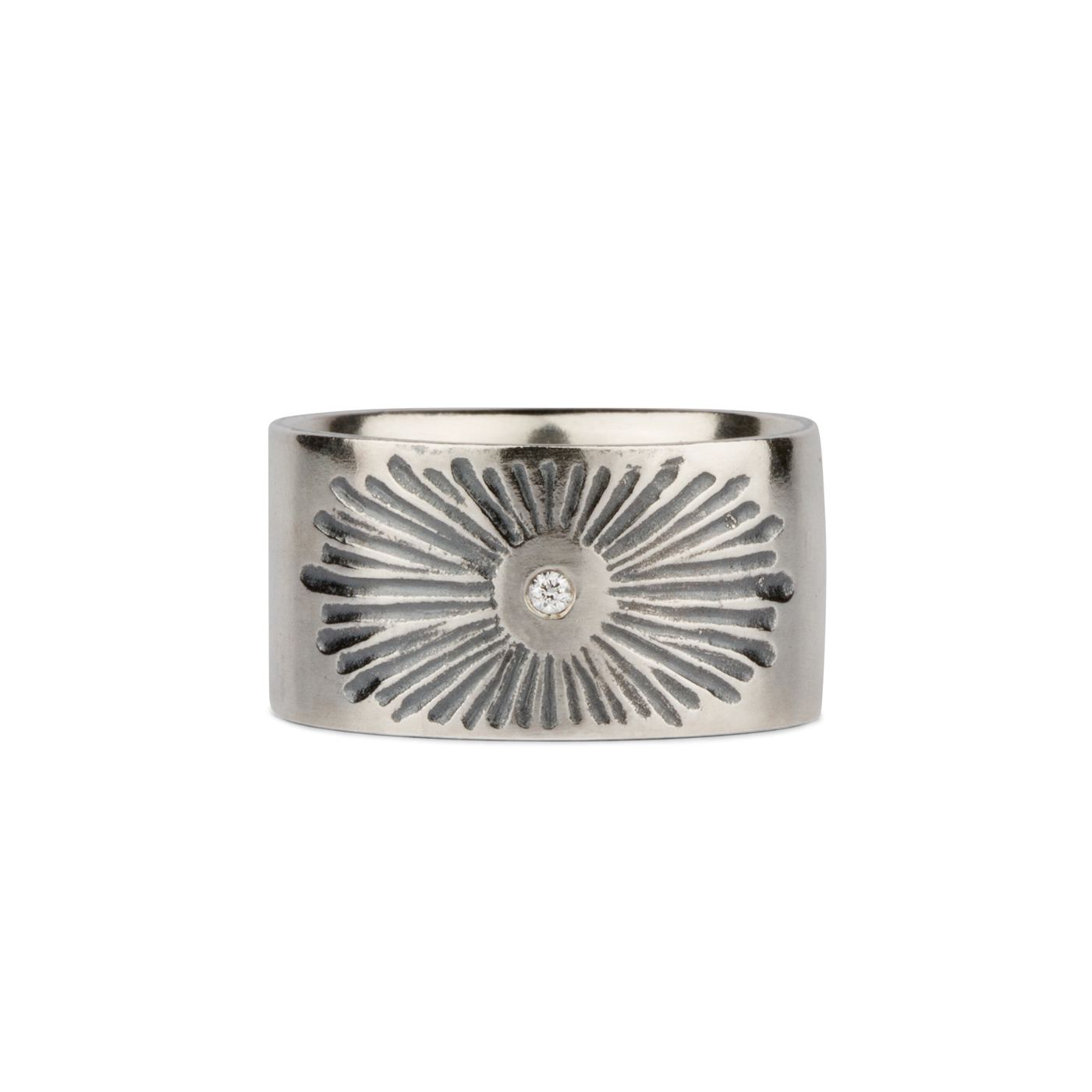 Oxidized silver wide band with single diamond and a carved sunburst design on a white background by Corey Egan