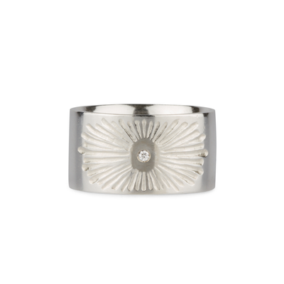 Sterlign silver wide band with single diamond and a carved sunburst design on a white background by Corey Egan
