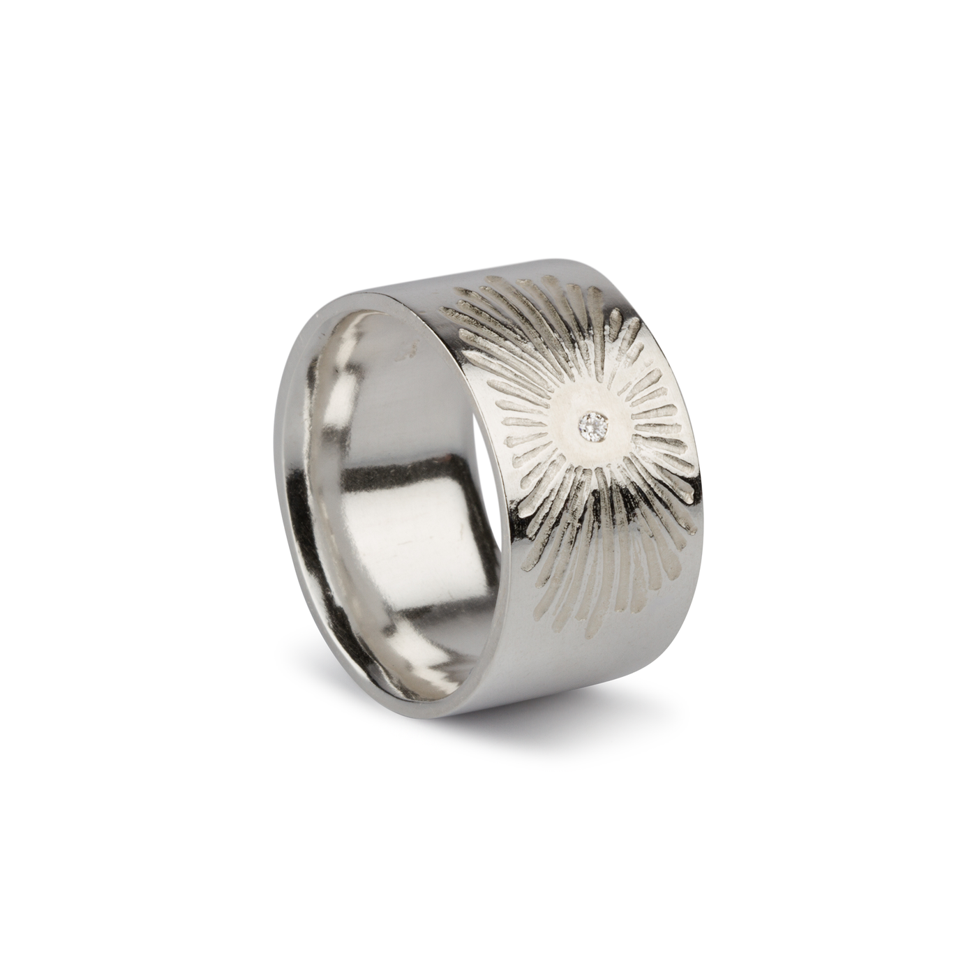 Sterling silver wide band with single diamond and a carved sunburst design side view on white by Corey Egan