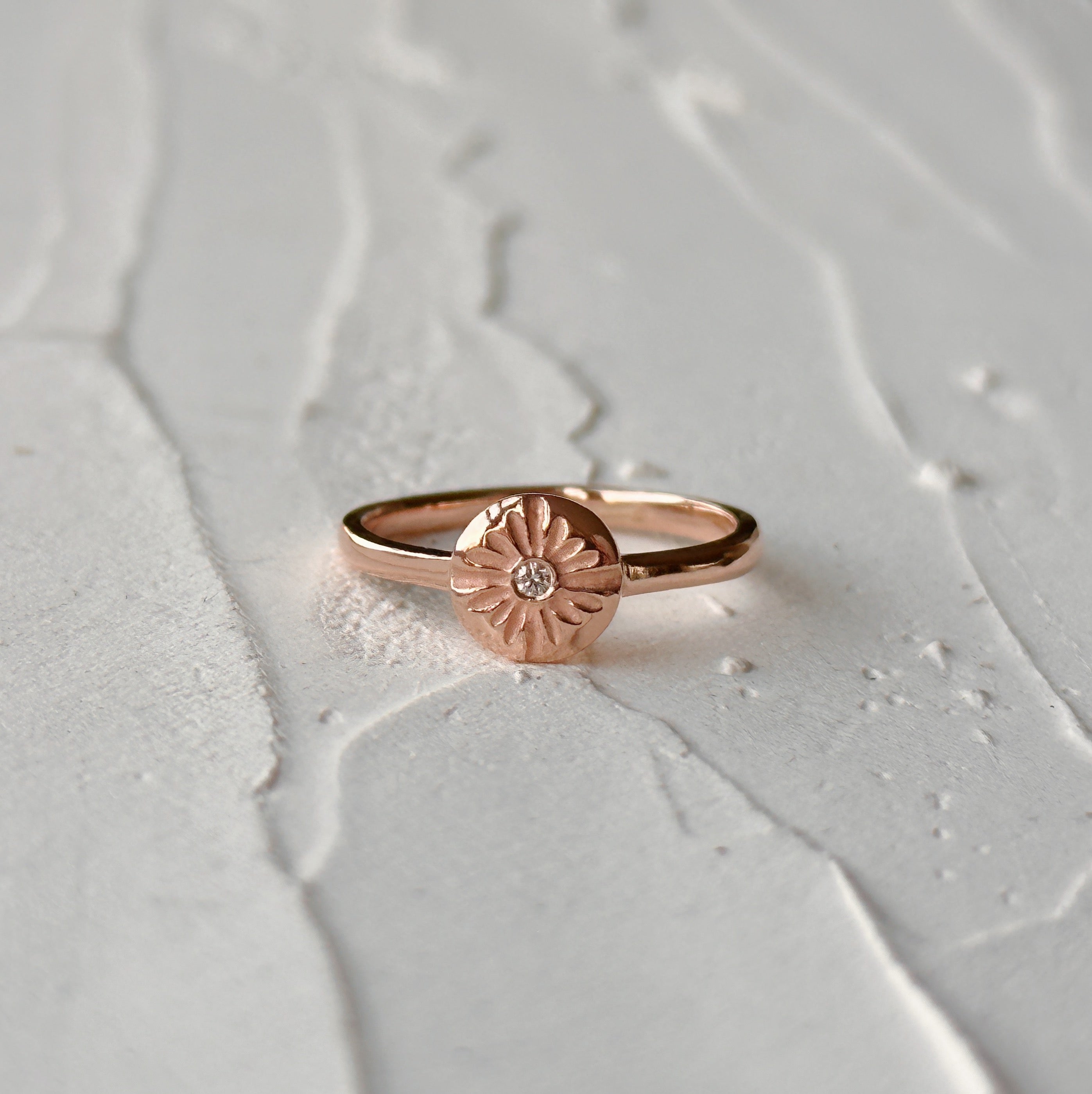 Lucia Small Rose Gold and Diamond Ring on a natural looking background