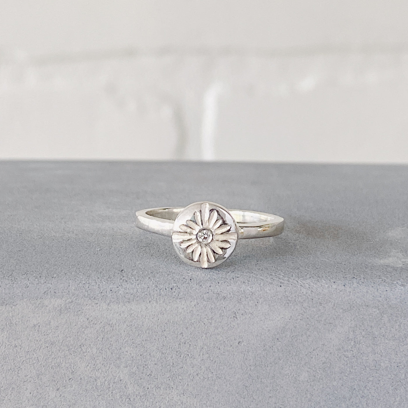 Small carved sunburst ring with a diamond center in sterling silver by Corey Egan