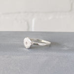 Small carved sunburst ring with a diamond center in sterling silver side view by Corey Egan