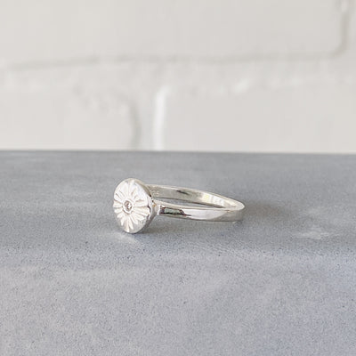 Small carved sunburst ring with a diamond center in sterling silver side view by Corey Egan