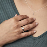 Small carved sunburst ring with a diamond center in sterling silver on a hand by Corey Egan