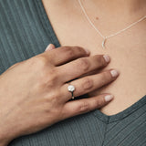 Small carved sunburst ring with a diamond center in sterling silver on a hand by Corey Egan