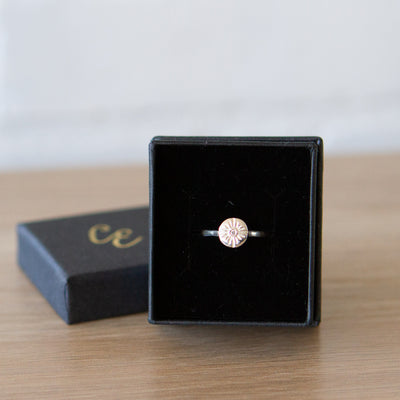 Small carved sunburst ring with a diamond center in sterling silver in a gift box by Corey Egan