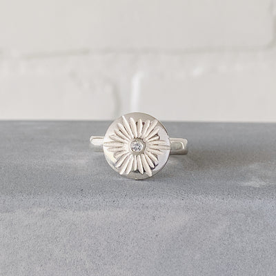 Large carved sunburst ring with a diamond center in sterling silver by Corey Egan