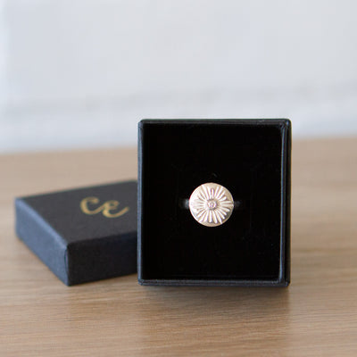 Large carved sunburst ring with a diamond center in sterling silver in a gift box by Corey Egan