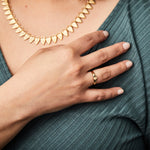Gold low profile signet ring with a hexagon face on a hand
