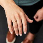 Gold low profile signet ring with a hexagon face on a hand