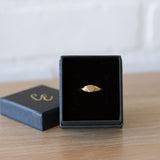 Gold low profile signet ring with a hexagon face in a gift box