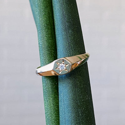 Low profile gold signet ring with hexagon top and a single white diamond set within a six pointed star setting