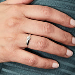 Low profile sterling silver signet ring with a hexagon shaped face and a white center diamond on a hand