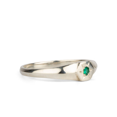 Other side view of sterling silver hexagon signet ring with a star set emerald in the center on a white background