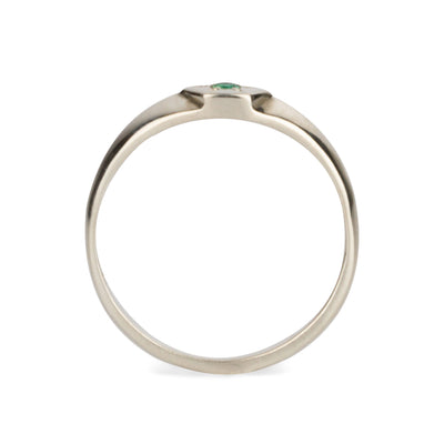 Profile view of sterling silver hexagon signet ring with a star set emerald in the center on a white background