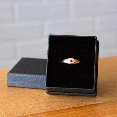 sterling silver hexagon signet ring with a star set ruby in the center in a gift box