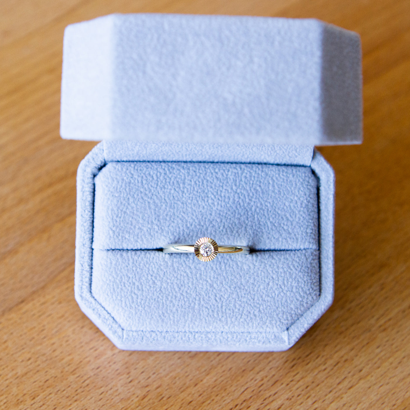 14k yellow gold large aurora stacking ring with a 3mm center diamond and engraved border in a ring box