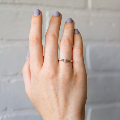 sterling silver large aurora stacking ring with a 3mm center diamond and engraved border on a hand