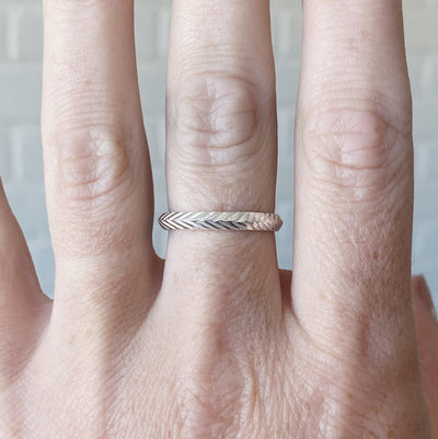 sterling silver stackable herringbone carved band on a hand 3mm width