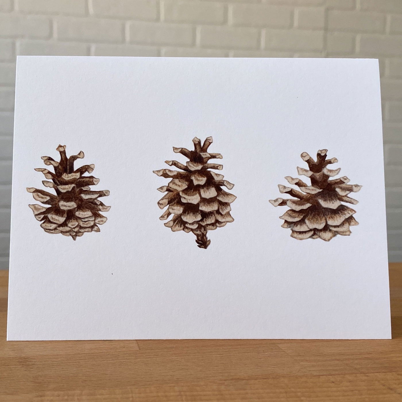 Watercolor card with three pinecones