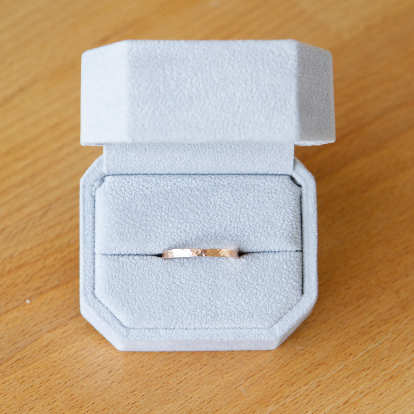 14k rose gold 2mm wide blue ridge hammered band in a gift box by Corey Egan