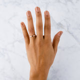 Thin 2mm Diablo flat brushed rose gold wedding band on a handby Corey Egan