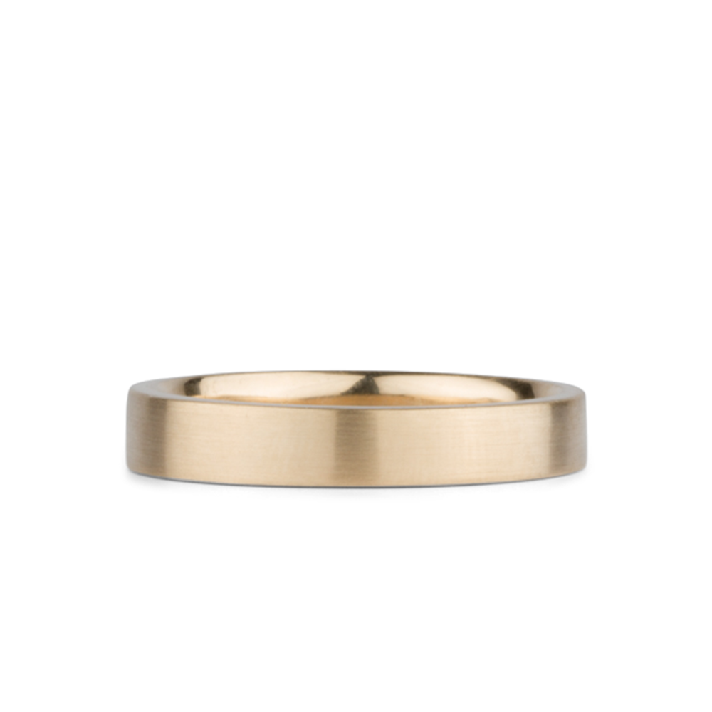 4mm Wide Diablo flat brushed yellow gold wedding band on a white background by Corey Egan