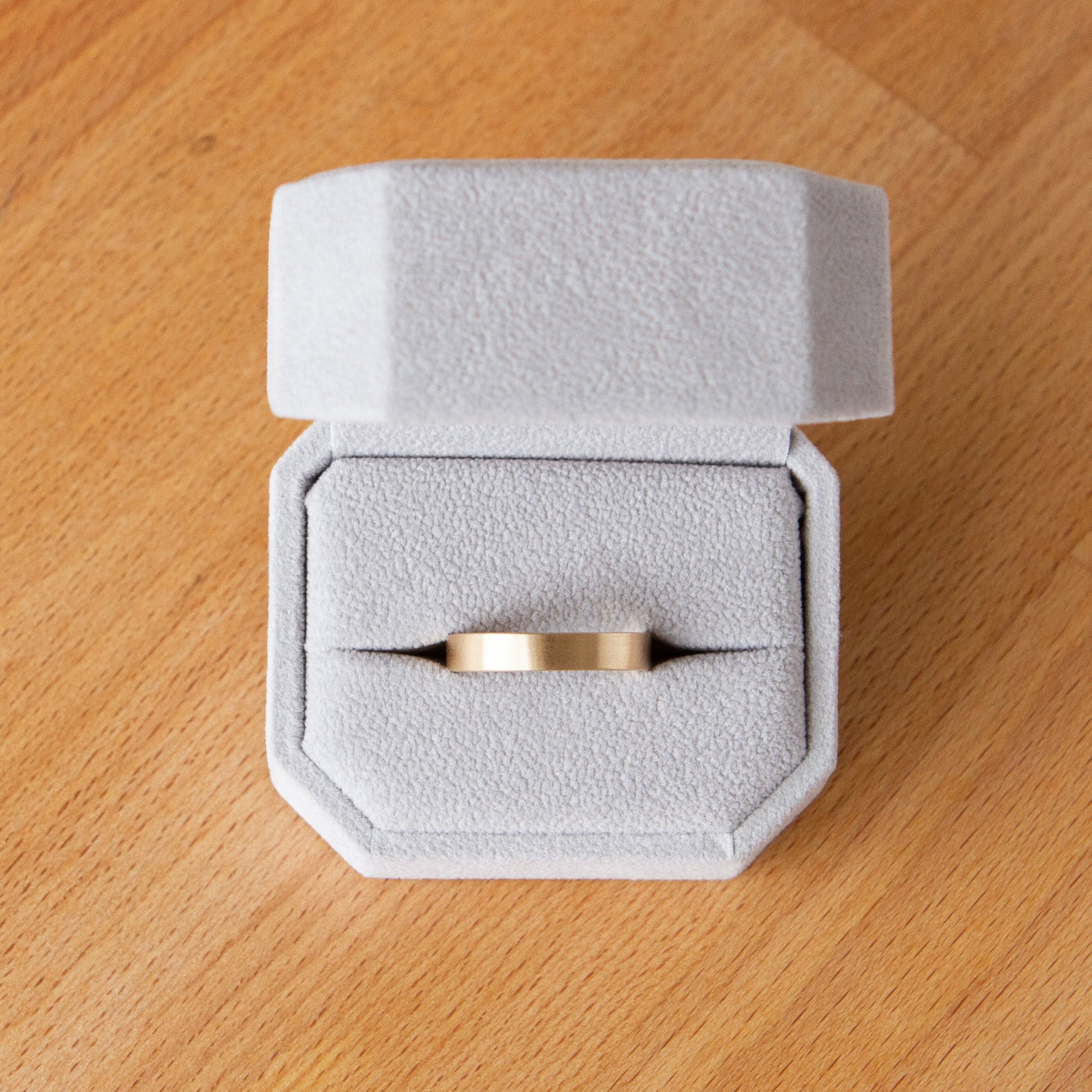 Wide Diablo flat brushed yellow gold wedding band in a ring box