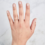 Thin half round Diablo rose gold brushed wedding band on a hand Corey Egan