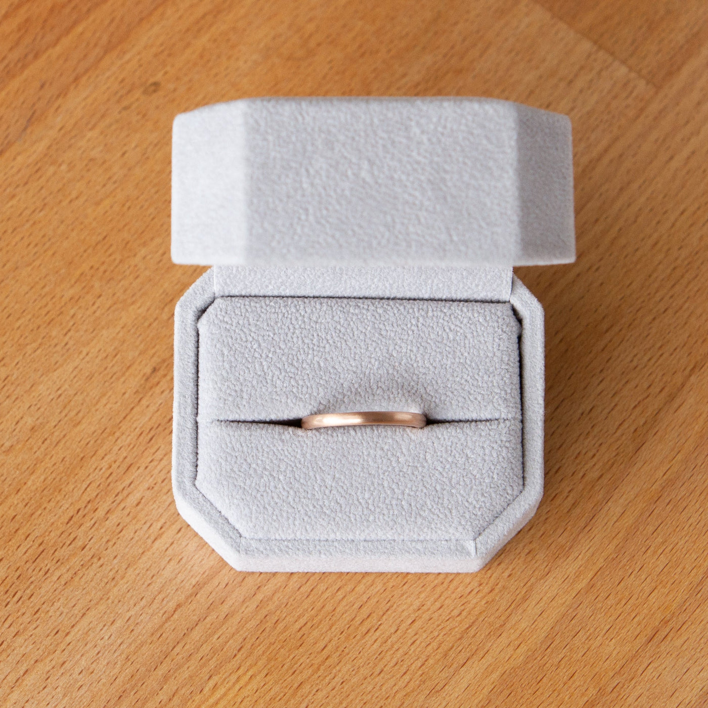 Thin half round Diablo rose gold brushed wedding band in a ring box
