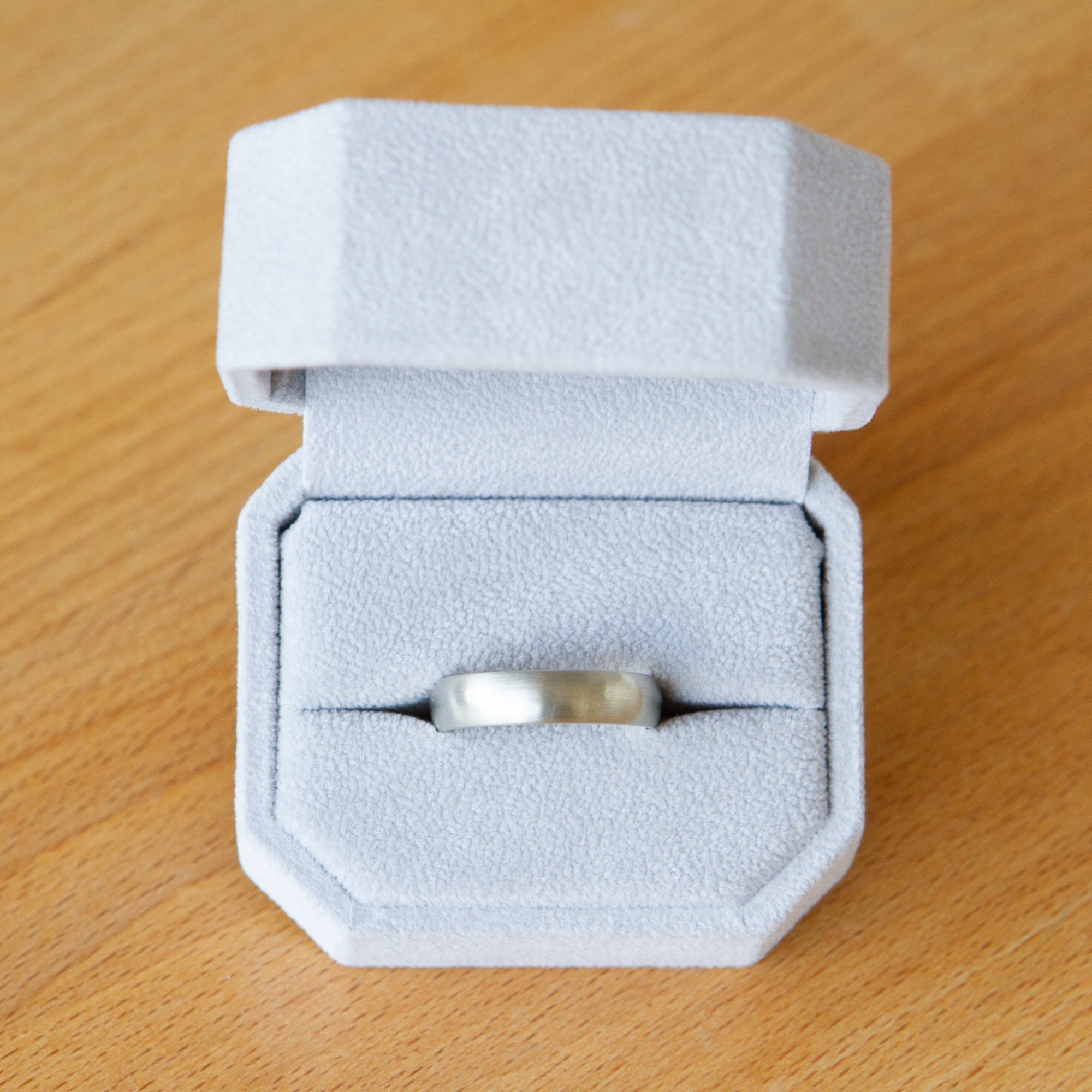 5mm wide 14k white gold half round band with brushed finish in a ring box
