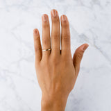 Thin half round Diablo yellow gold brushed wedding band on a hand by Corey Egan