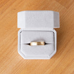 Wide half round Diablo brushed wedding band in yellow gold in a ring box