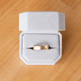 Wide half round Diablo brushed wedding band in yellow gold in a ring box