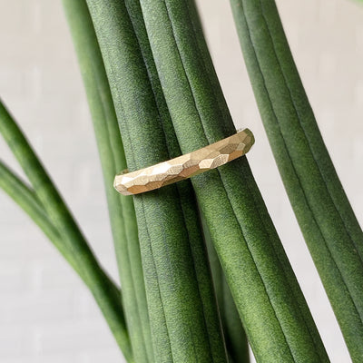 Thin faceted yellow gold wedding band 3mm wide in natural light