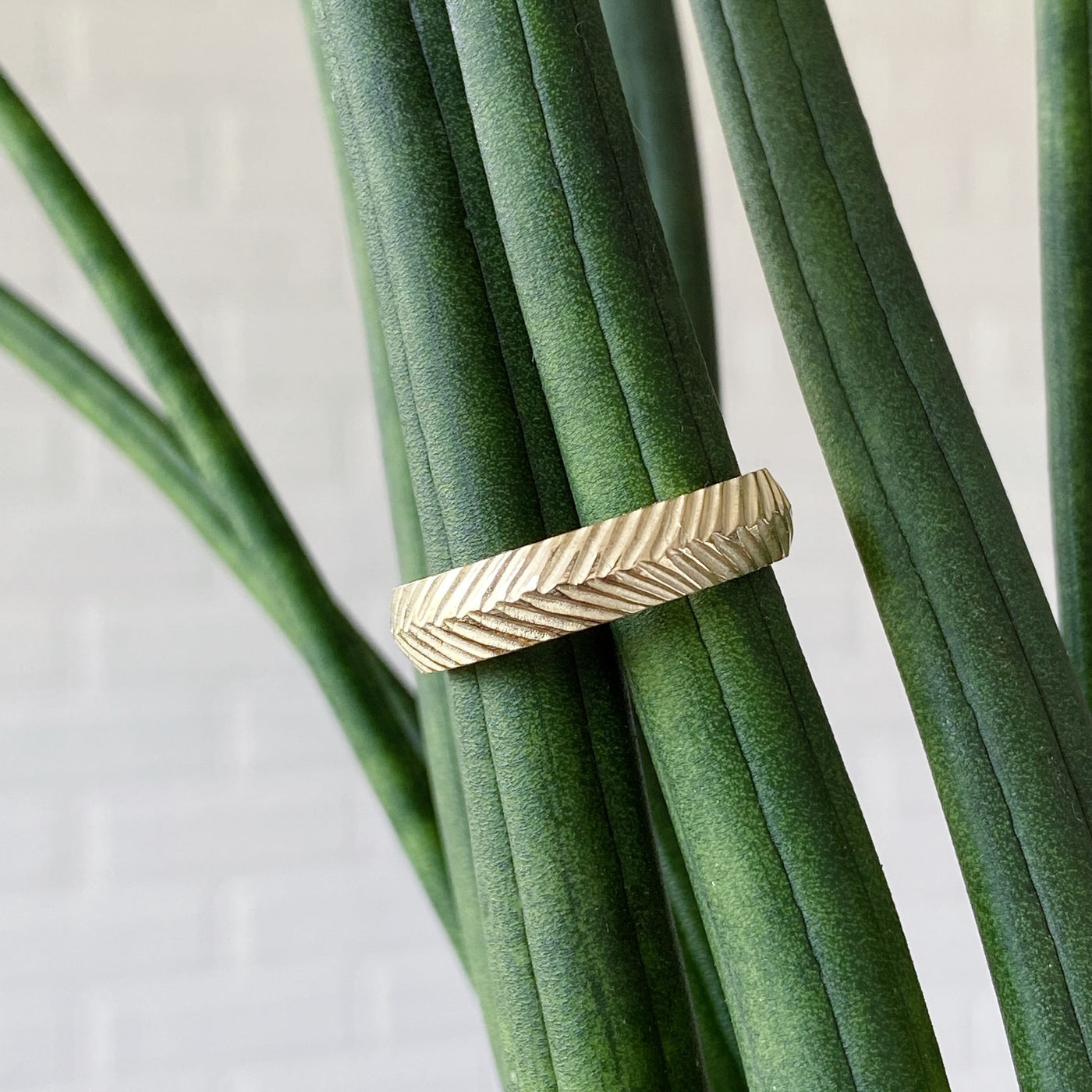 Herringbone yellow gold carved wedding band in natural light. 