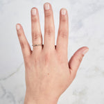 Yellow gold Lassen Diamond Band with flush set equidistant diamonds on a hand by Corey Egan