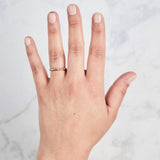 Yellow gold Lassen Diamond Band with flush set equidistant diamonds on a hand by Corey Egan