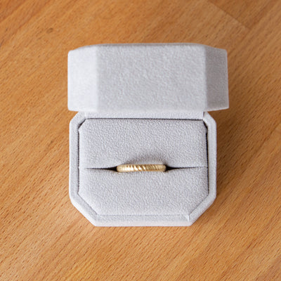 Mackinac 14k yellow gold carved sandy surface wedding band in a ring box