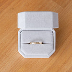 Shiny muir flat thin yellow gold wedding band in a ring box