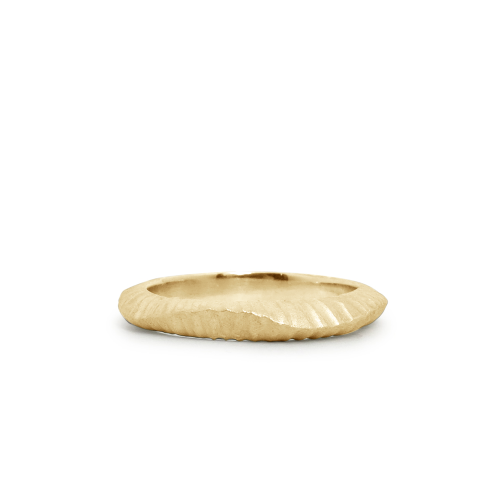 14k yellow gold undulating carved texture wedding band by Corey Egan on a whtie background