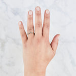 Peaked 14k yellow gold band with five white diamonds in delicate star settings on a hand