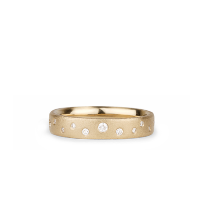 Yellow gold matte texture wide wedding band with scattered flush set diamonds by Corey Egan on a white background