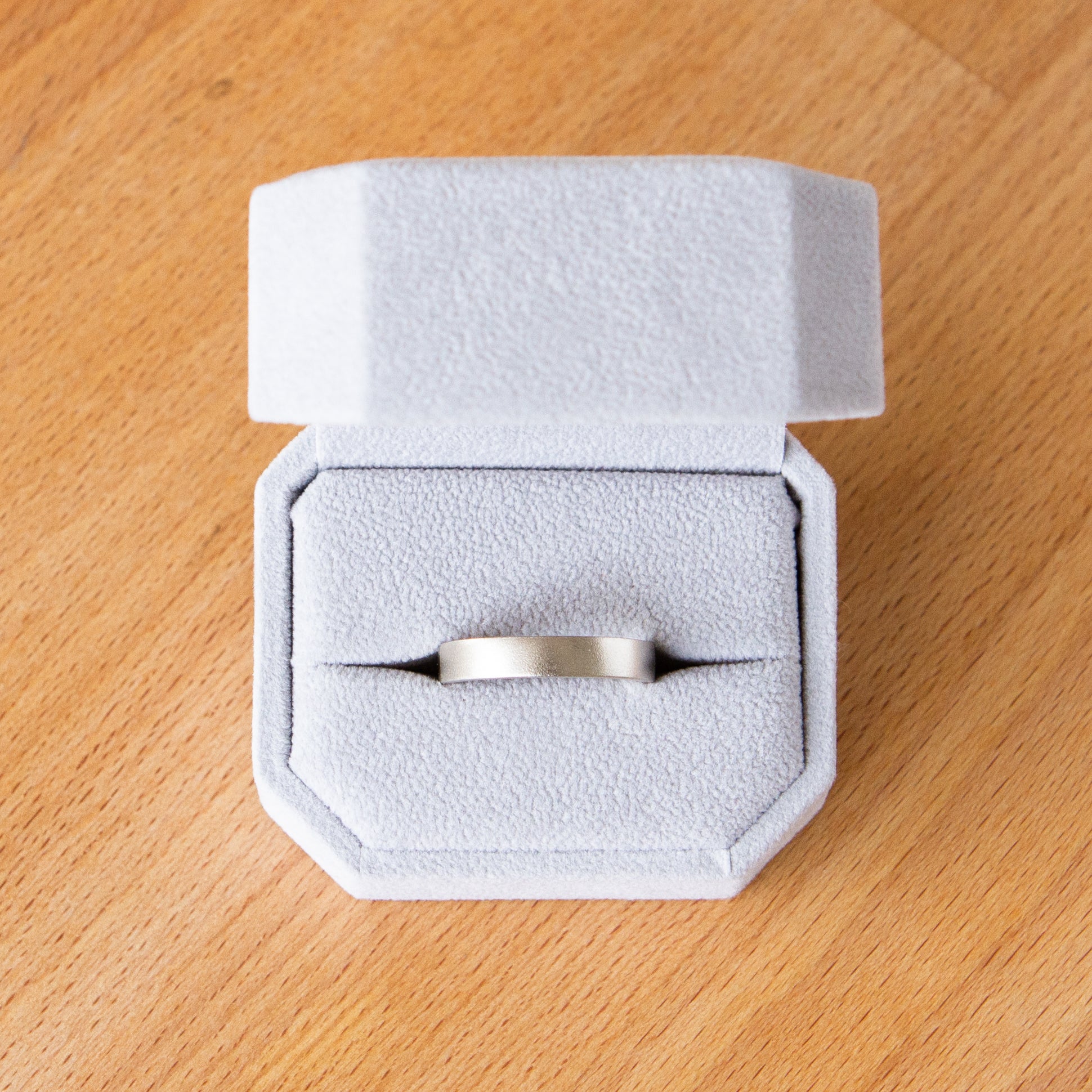 4mm wide white gold Yosemite flat stippled texture wedding bands in a ring box