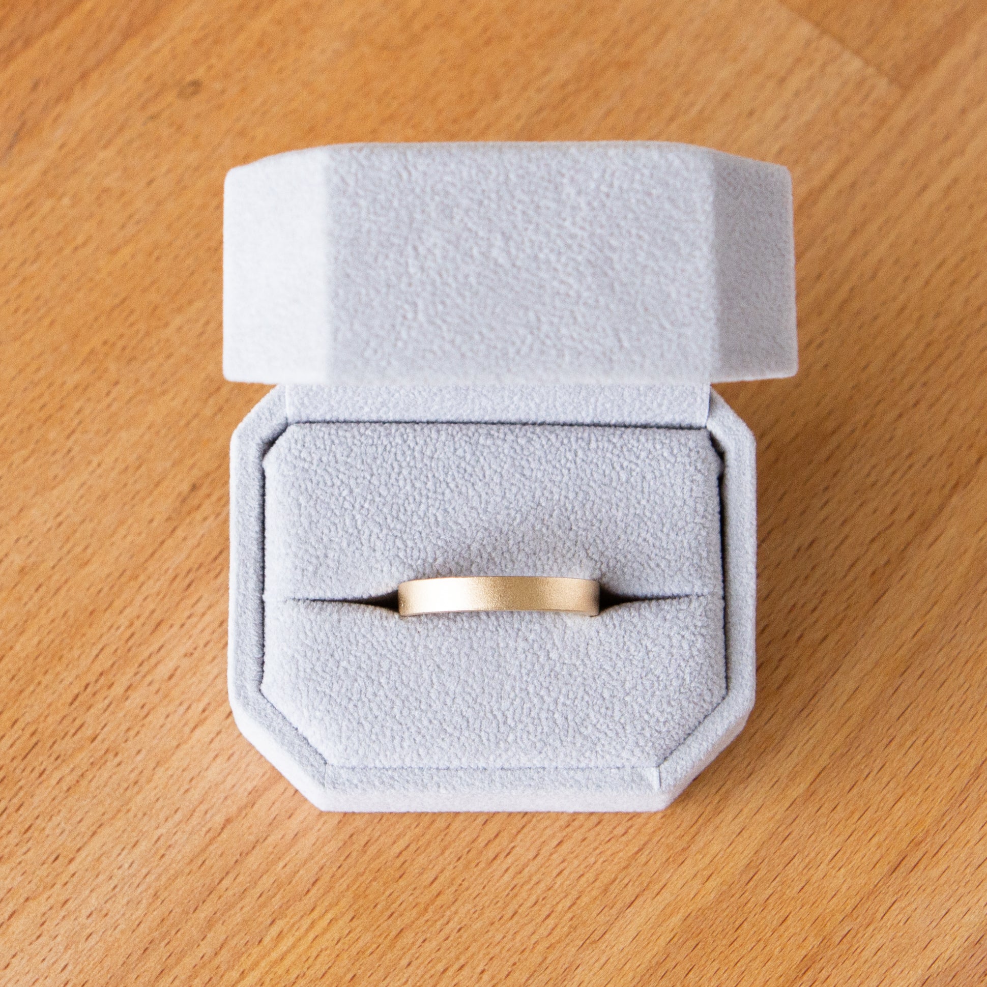 4mm wide yellow gold Yosemite flat stippled texture wedding bands in a ring box