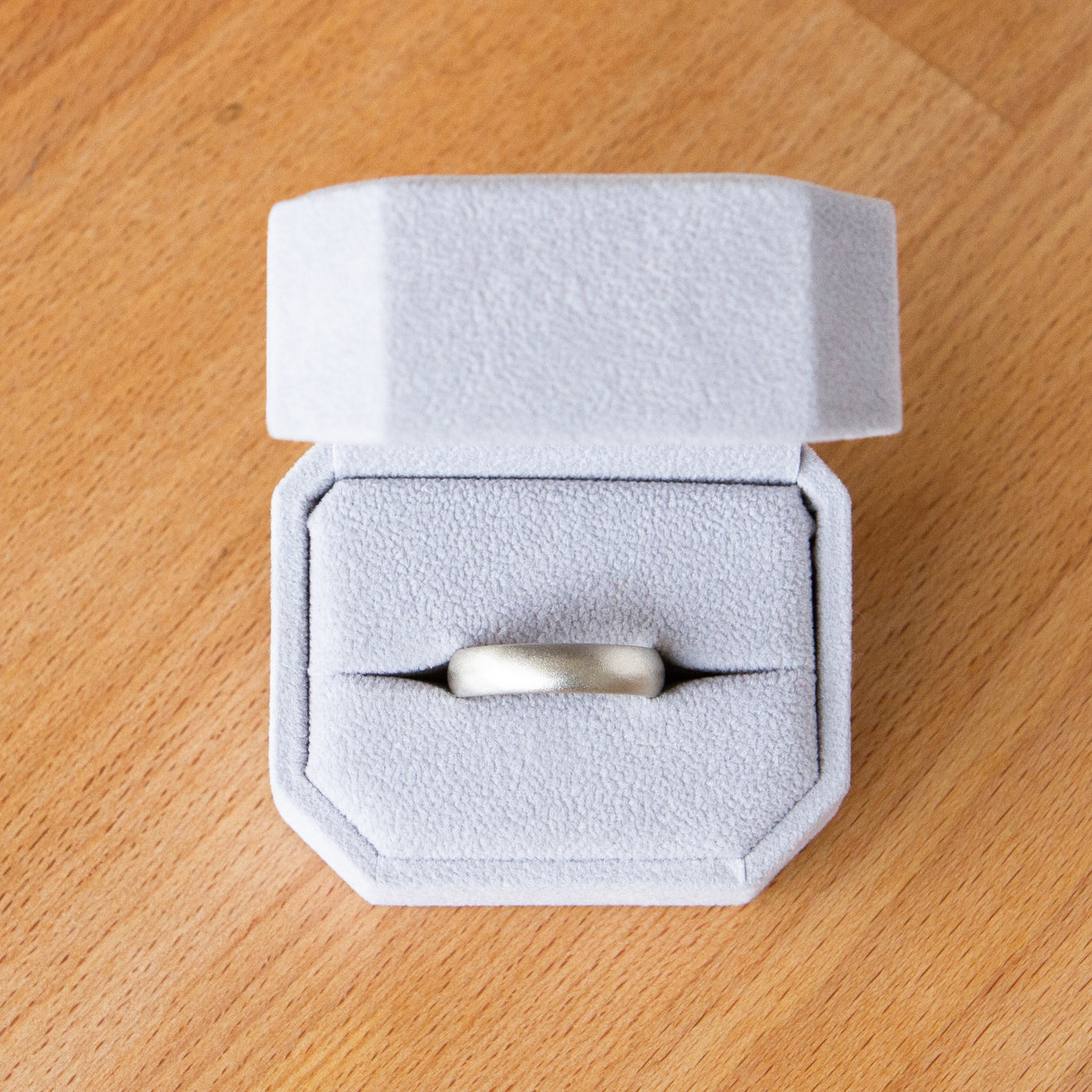 White gold Yosemite half round stippled texture wedding band in a ring box