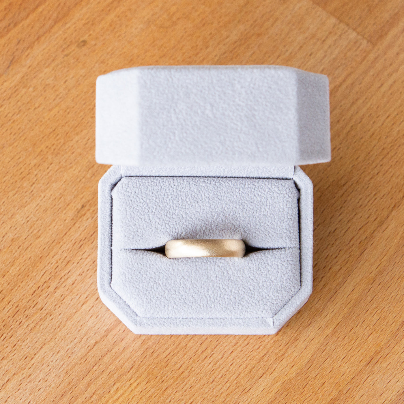 Yellow gold Yosemite half round stippled texture wedding band in a ring box