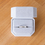 14k white gold thin zion flat vertical hammered wedding band in a ring box